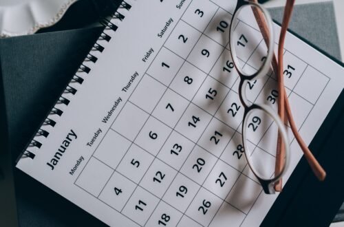Óculos de leitura apoiados sobre um calendário mensal impresso